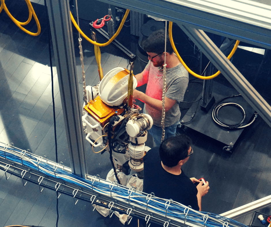 Engineers working on robot inside Building 9 of Space Center Houston
