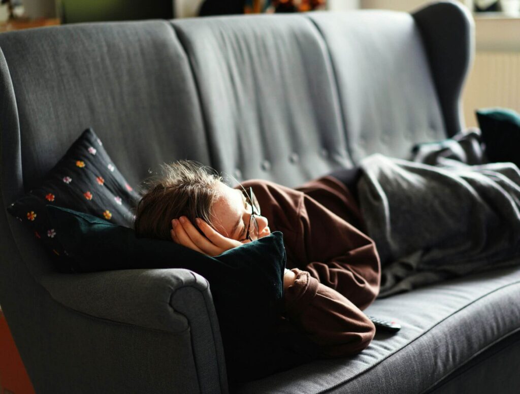 Woman lying on couch watching tv