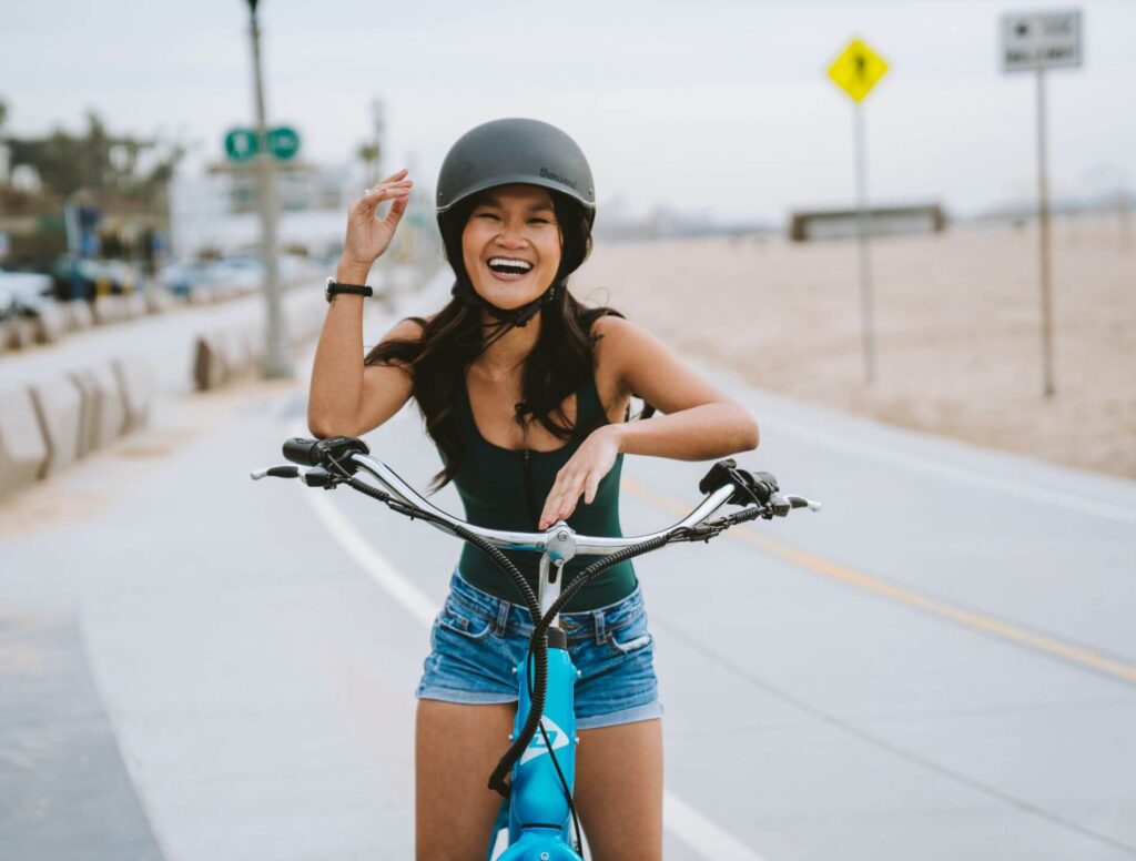 Young woman  standing with her bike while wearing a helmet